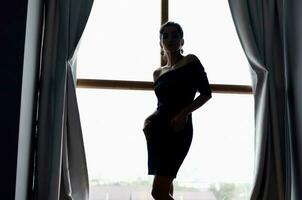 woman silhouette near window interior posing model photo