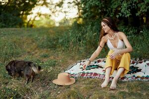 A hippie woman playing in nature with her little dog photo