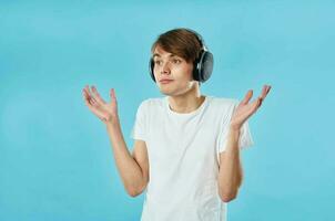 guy in white t-shirt wearing headphones emotions music technology blue background photo