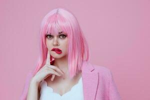 retrato de un encantador dama gestos con su manos con un rosado chaqueta rosado antecedentes inalterado foto