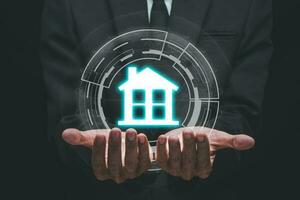 House or Family Insurance Concept, Home Icon floating over a Careful Gesture Hand of a Businessman, Concept of home and real estate Property insurance. photo