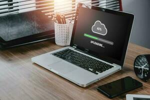 Upload data concept, laptop computer screen display show waiting for cloud uploading on laptop in office, Data infomation, Technology network internet Concept. photo