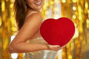 Young woman with heart over gold background photo