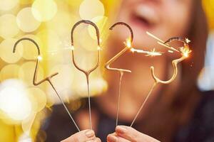 Woman holding 2023 sparklers at new year eve photo