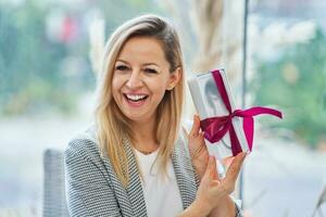 Picture of woman holding a gift in restaurant photo