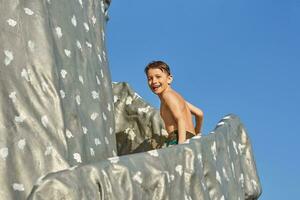 Picture of young boy playing in outdoor aqua park photo