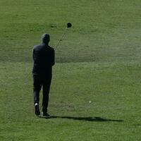 Golfer lining up his stroke photo