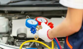 Technician man check car air conditioning system refrigerant recharge, Repairman holding monitor tool to check and fixed car air conditioner system, Air Conditioning Repair photo