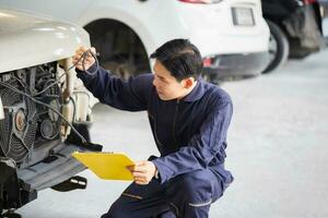 coche mecánico con un Lista de Verificación, técnico comprobación moderno coche a cochera, coche reparar y mantenimiento conceptos foto