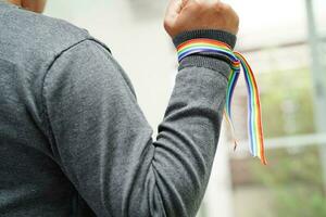 Asian woman with rainbow flag, LGBT symbol rights and gender equality, LGBT Pride Month in June. photo