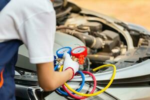 Repairman holding monitor tool to check and fixed car air conditioner system, Technician man check car air conditioning system refrigerant recharge, Air Conditioning Repair photo