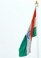 India flag flying high at Connaught Place with pride in blue sky, India flag fluttering, Indian Flag on Independence Day and Republic Day of India, tilt up shot, Waving Indian flag, Har Ghar Tiranga photo