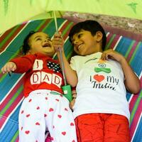 Two happy boys in society park, happy Asian brothers who are smiling happily together. Brothers play outdoors in summer, best friends. Toddler baby boy playing with his happy brother in the garden photo