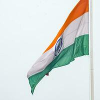 India flag flying high at Connaught Place with pride in blue sky, India flag fluttering, Indian Flag on Independence Day and Republic Day of India, tilt up shot, Waving Indian flag, Har Ghar Tiranga photo