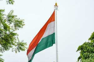 India flag flying high at Connaught Place with pride in blue sky, India flag fluttering, Indian Flag on Independence Day and Republic Day of India, tilt up shot, Waving Indian flag, Har Ghar Tiranga photo