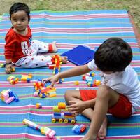 Two happy boys in society park, happy Asian brothers who are smiling happily together. Brothers play outdoors in summer, best friends. Toddler baby boy playing with his happy brother in the garden photo