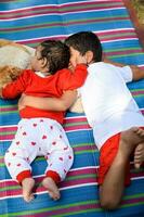 dos contento Niños en sociedad parque, contento asiático hermanos quien son sonriente felizmente juntos. hermanos jugar al aire libre en verano, mejor amigos. niñito bebé chico jugando con su contento hermano en el jardín foto