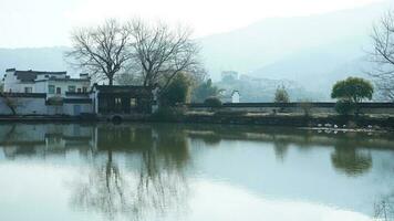 One old traditional Chinese village view with the old arched stone bridge and old wooden buildings in the Southern countryside of the China photo