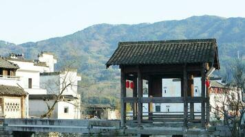 One old traditional Chinese village view with the old arched stone bridge and old wooden buildings in the Southern countryside of the China photo