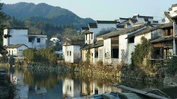 The beautiful traditional Chinese village view with the classical architecture and fresh green trees as background photo