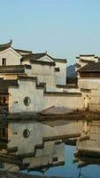 The beautiful traditional Chinese village view with the classical architecture and fresh green trees as background photo