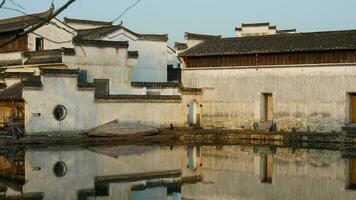 The beautiful traditional Chinese village view with the classical architecture and fresh green trees as background photo