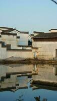 The beautiful traditional Chinese village view with the classical architecture and fresh green trees as background photo