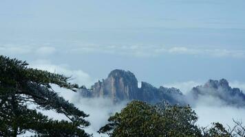 The beautiful mountains view surrounded by the misty fog in winter photo