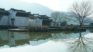 uno antiguo tradicional chino pueblo ver con el antiguo arqueado Roca puente y antiguo de madera edificios en el del Sur campo de el China foto