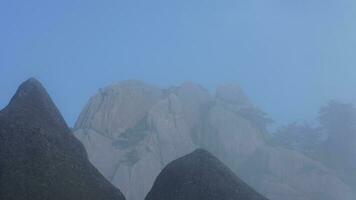 The beautiful mountains view surrounded by the misty fog in winter photo