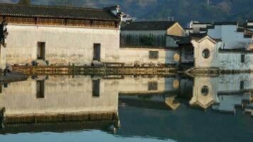 The beautiful traditional Chinese village view with the classical architecture and fresh green trees as background photo