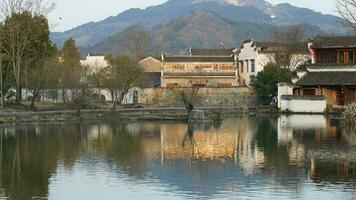 The beautiful traditional Chinese village view with the classical architecture and fresh green trees as background photo