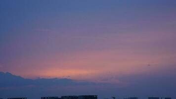 The beautiful sunset view with the buildings' silhouette and orange color sky as background in the city photo