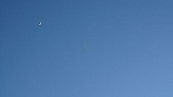 The blue sky view with the curve white moon in the sky in the day photo