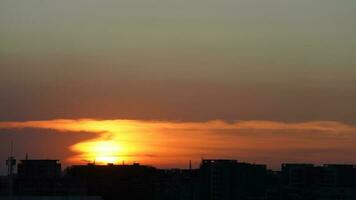 el hermosa puesta de sol ver con el edificios' silueta y naranja color cielo como antecedentes en el ciudad foto