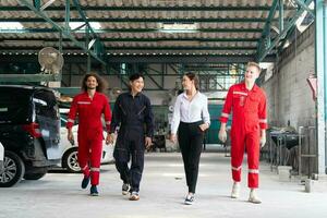 joven confidente gerentes y coche mecánica equipo en uniforme son trabajando en auto servicio. coche reparar y mantenimiento conceptos foto