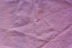 The texture of the fabric is pink. Horizontal stitches. The fabric is wrinkled. photo