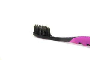 Charcoal toothbrush on a white background that cleans teeth with charcoal, designed for health-conscious people, environmentally friendly. photo