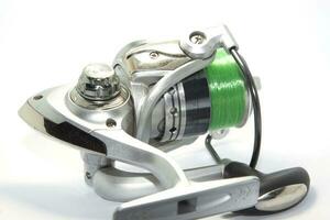 Fishing reels is a leisure sport or hobby of the unemployed, fishing is a popular thing for people to fish to eat and is a sport on a white background. photo