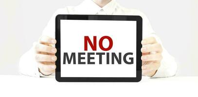 Text no meeting on tablet display in businessman hands on the white background. Business concept photo