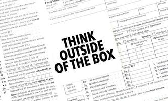 think outside of the box on white sticker and documents photo