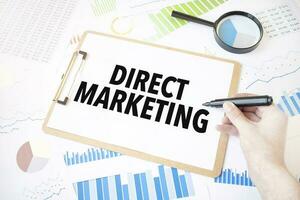 Text direct marketing on white paper sheet and marker on businessman hand on the diagram. Business concept photo