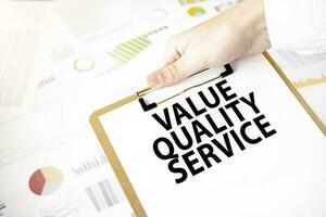 Text value quality service on white paper plate in businessman hands with financial diagram. Business concept photo