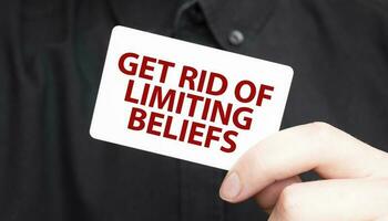 Businessman holding a card with text get rid of limiting beliefs, business concept photo