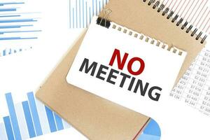 Text no meeting on white paper sheet and brown paper notepad on the table with diagram. Business concept photo