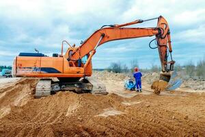 male Worker in uniform use vibratory plate compactor for path construction. photo