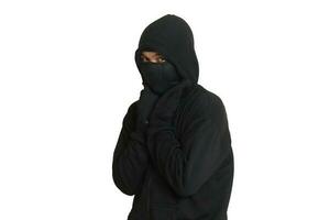 Mysterious man wearing black hoodie standing and looking at camera. Isolated image on gray background photo