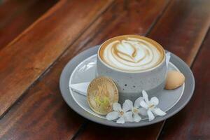 un taza de capuchino con bitcoin en de madera mesa a cafetería. criptomoneda comercio concepto foto