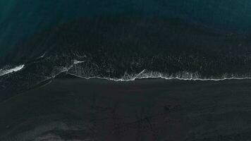 superiore Visualizza di un' ragazza a piedi su il spiaggia con nero sabbia, costa di il atlantico oceano. tenerife, canarino isole, Spagna video