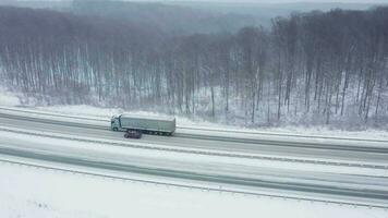 top visie van verkeer Aan een weg omringd door winter Woud. toneel- winter landschap video